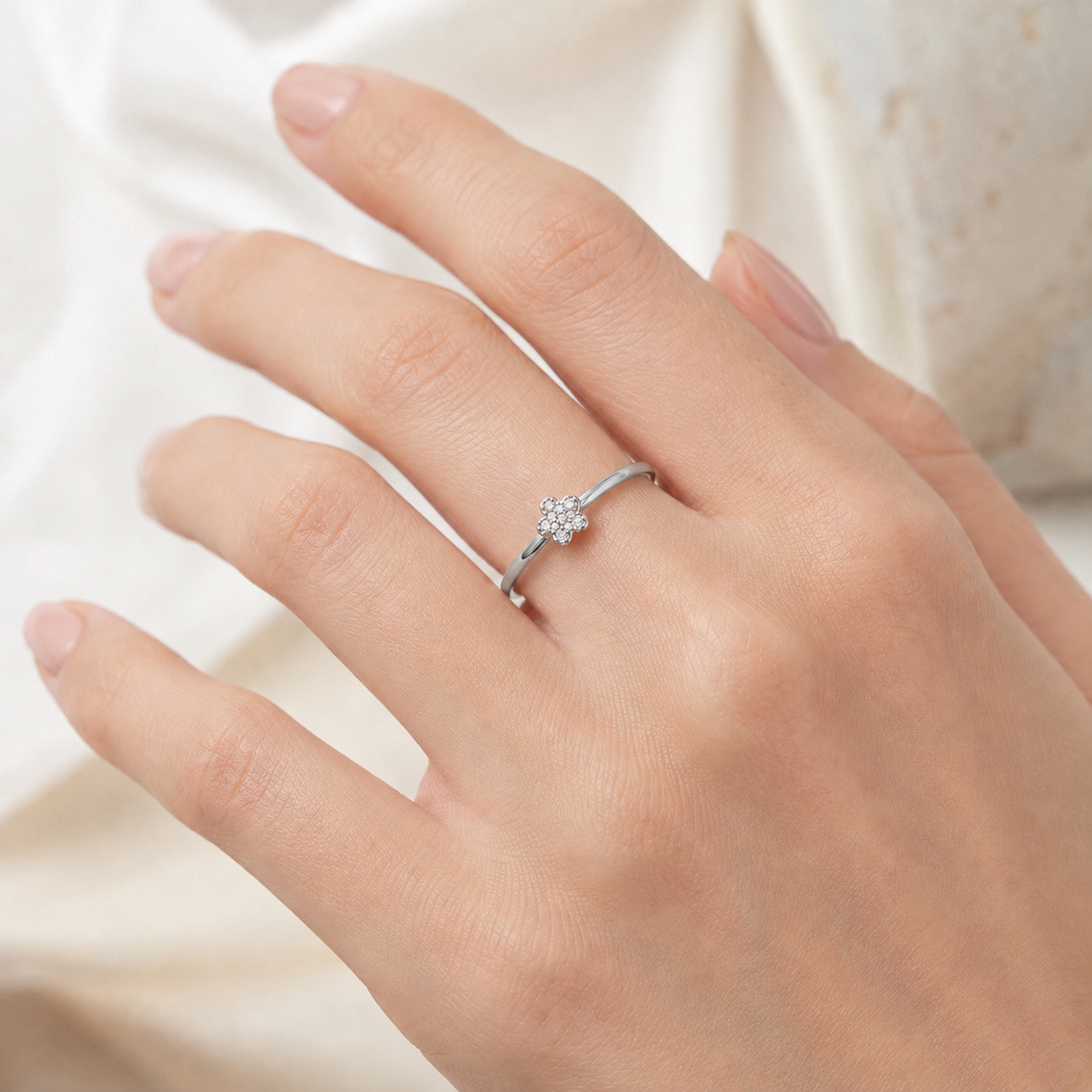 Weißgold Ring mit Zirkoniasteinen im Blüten Design getragen
