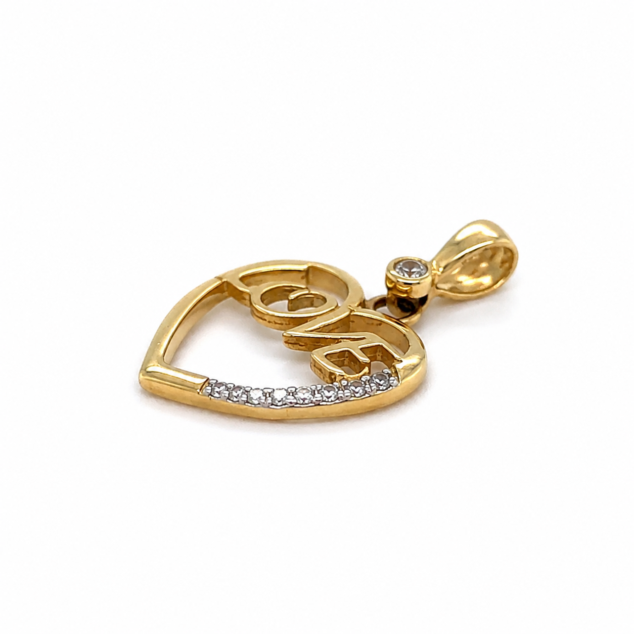 Herzanhänger aus 585 Gelbgold mit LOVE-Schriftzug und funkelnden Zirkonia liegend fotografiert
