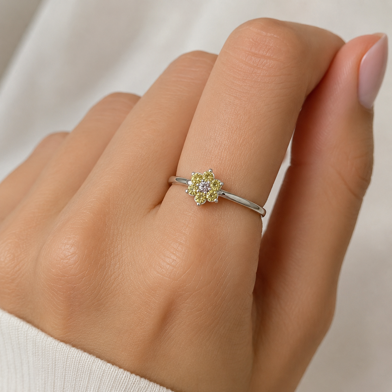 Zarter Ring aus 925er Silber mit Zirkonia in floraler Anordnung getragen