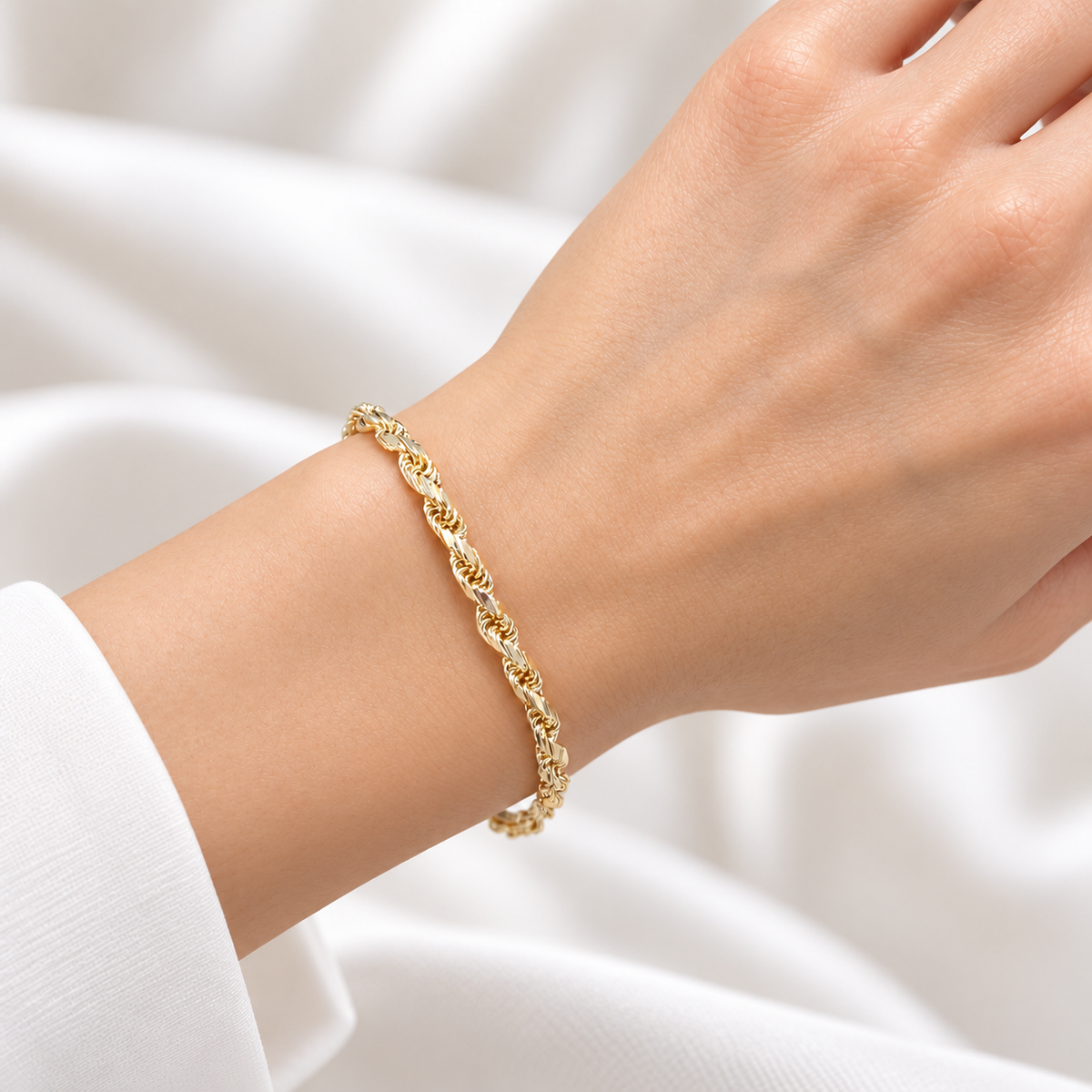 Kordelarmband aus 585 Gelbgold mit glänzend poliertem Kordelmuster und Karabinerverschluss in getragener Ansicht auf weißem Hintergrund.