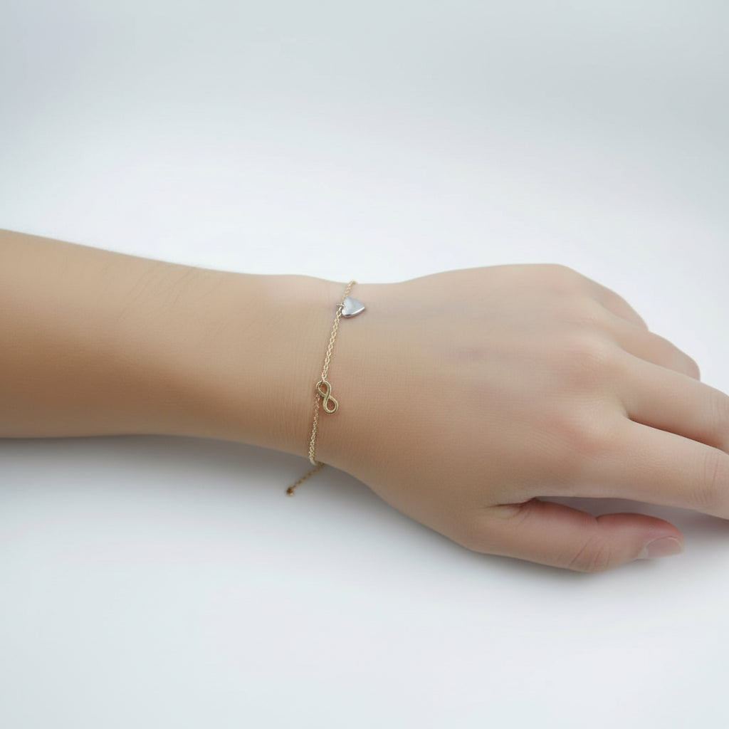 Feines Bettelarmband 585 Gold mit Symbolanhängern am Handgelenk