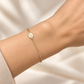 Nahansicht eines getragenen Maria-Armbands aus 585 Gelbgold mit reliefierter Marienmedaille und feiner Ankerkette.