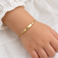 Babyarmband aus 585 Gelbgold mit Gravurplatte und Figarokette am Kinderhandgelenk getragen
