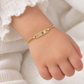 Babyarmband aus 585 Gelbgold mit verzierter Gravurplatte am Kinderhandgelenk getragen