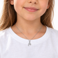 Kind mit weißem Shirt trägt einen zierlichen Delfin-Anhänger aus 585 Weißgold mit Zirkonia an einer feinen Kette.