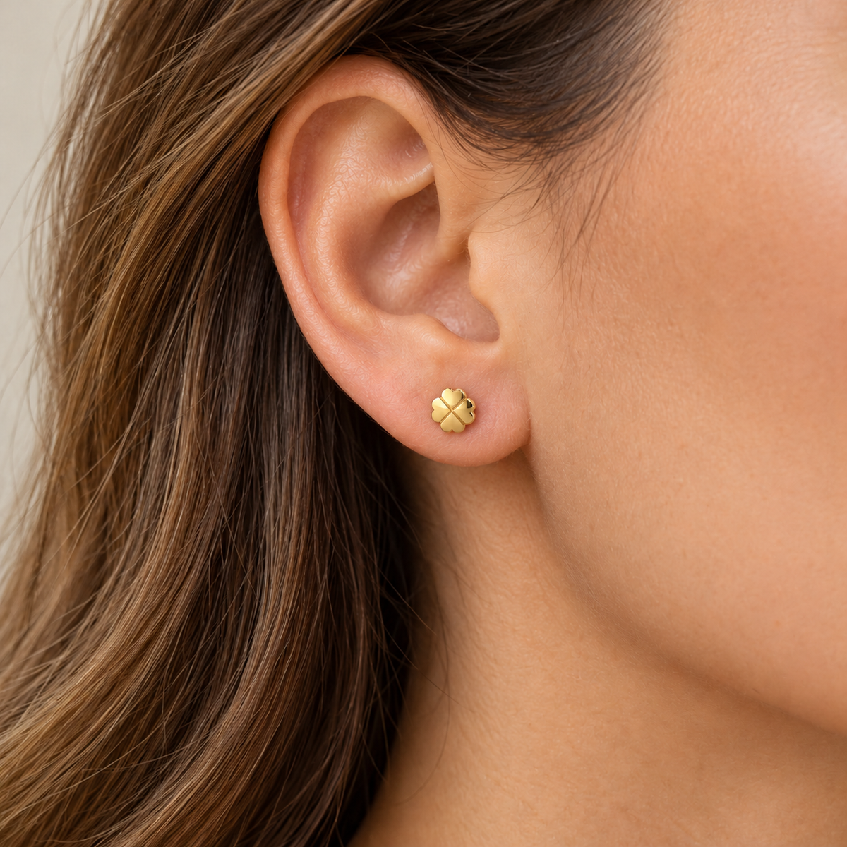 Kleiner Kleeblatt-Ohrstecker aus 585 Gelbgold mit ca. 5,3 mm Durchmesser am Ohr getragen.